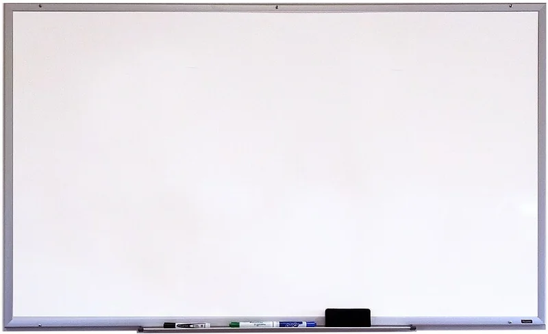 Blank whiteboard with markers and an eraser